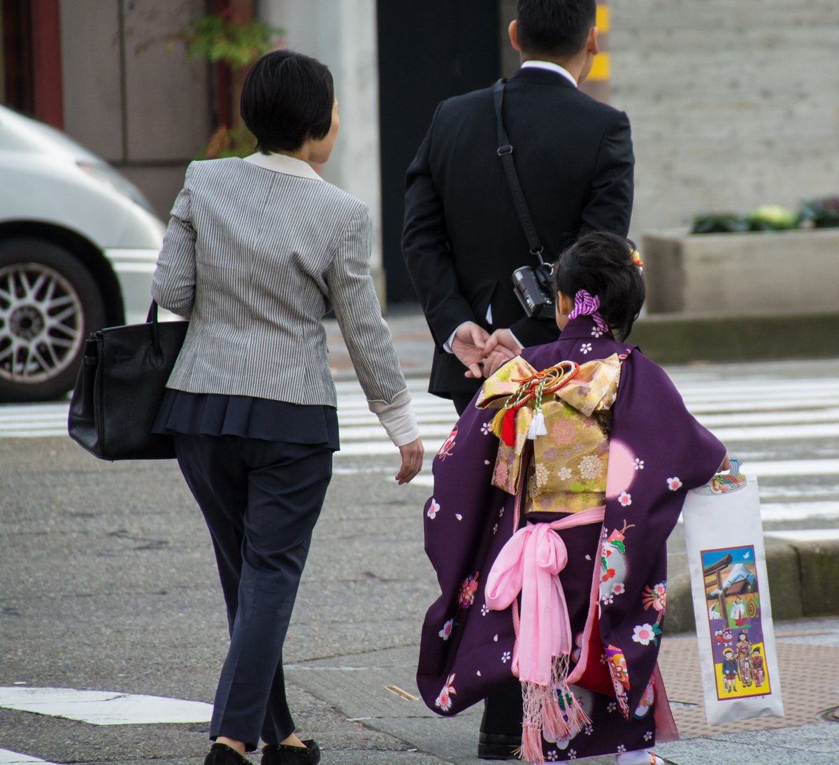着物姿の子どもと大人が並んで歩く後ろ姿。七五三の参考写真